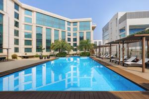 a swimming pool in front of a building at Pride Plaza Hotel, Aerocity New Delhi in New Delhi