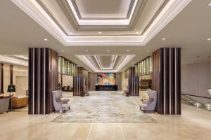 a lobby with chairs and a large painting on the ceiling at Pride Plaza Hotel, Aerocity New Delhi in New Delhi