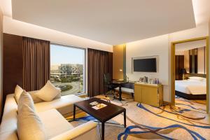 a hotel room with a couch and a bed at Pride Plaza Hotel, Aerocity New Delhi in New Delhi