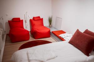 a bedroom with red pillows and a bed and a couch at Luttokolo, Saariselkä in Saariselka