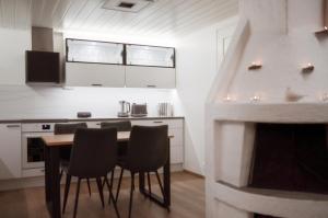 eine Küche mit einem Tisch und Stühlen sowie einem Kamin in der Unterkunft Luttokolo, Saariselkä in Saariselkä
