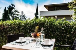 a table with a bottle and a bowl of fruit on it at Appartamenti Meridiana in Torri del Benaco