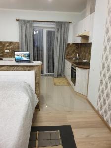 a bedroom with a bed and a kitchen with a laptop on a counter at Квартира-студія in Lutsk