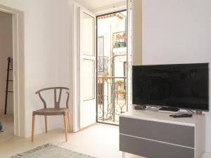 a living room with a flat screen tv and a chair at Bica lisbon sunshine central bright and cozy apt in Lisbon