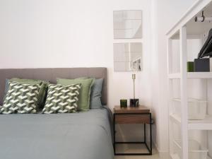リスボンにあるBica lisbon sunshine central bright and cozy aptのベッドルーム1室(ベッド1台付)、棚の横にナイトスタンドが備わります。
