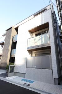 ein weißes Backsteingebäude mit Fenstern auf einer Straße in der Unterkunft 5 minutes Shin-Osaka 9 in Osaka