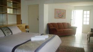 a bedroom with a large bed and a couch at Thoko-Zani Beach House in KwaDukuza