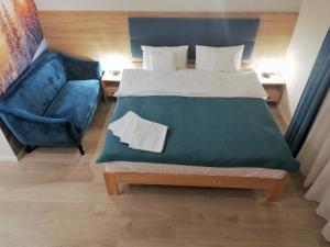 um quarto com uma cama grande e uma cadeira azul em U ŹRÓDEŁ em Wisla