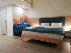 1 dormitorio con 1 cama grande y cabecero azul en U ŹRÓDEŁ en Wisła