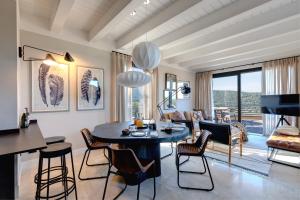 a living room with a table and chairs at Argentario Golf Villas in Porto Ercole