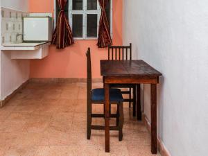 a wooden table and chairs in a room with a window at Casa Cuevas & Amaro in Mérida