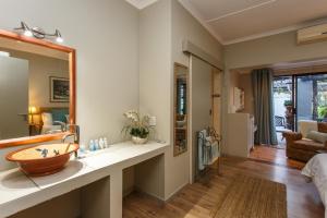 uma casa de banho com um lavatório e um espelho grande em Argyll B&B em Oudtshoorn