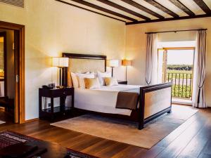 a bedroom with a bed and a large window at Abadia Retuerta LeDomaine in Sardoncillo