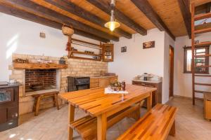 a kitchen with a wooden table and a fireplace at House Jure in Tkon