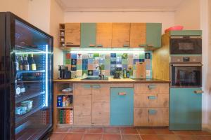 a kitchen with wooden cabinets and a blue refrigerator at Le Remise in Potsdam