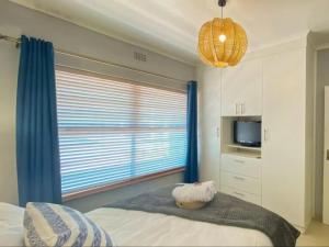 1 dormitorio con cama y ventana grande en 3 Sea View Lodge, en Langebaan