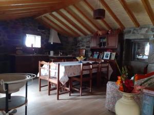 una cucina e una sala da pranzo con tavolo e sedie di A casa do pátio a Montalegre