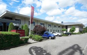 a building with a car parked in front of it at Bastion Hotel Schiphol Hoofddorp in Hoofddorp