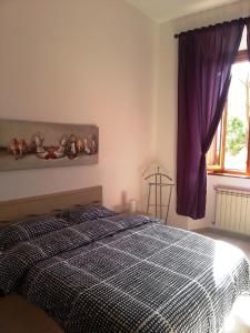 Schlafzimmer mit einem schwarzen und weißen Bett und einem Fenster in der Unterkunft Calamatta's House in Civitavecchia