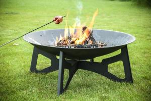 a person is stirring a grill with a stick at Penzion Betlém in Hlinsko