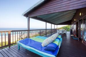 a bed on a deck with the ocean in the background at Mar Azul 6, Ponta do Ouro road, Ponta Malongane in Ponta Malongane