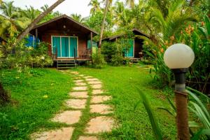 a path leading to a resort with a house at Montego Bay Beach Village - Morjim in Morjim