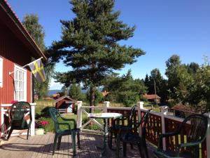 a deck with chairs and a table and a tree at Kullsbjörken Bed & Breakfast in Tällberg