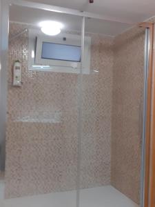 a bathroom with a shower with a tv on the wall at A casa do pátio in Montalegre