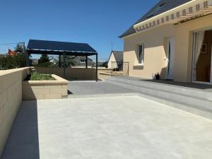 une terrasse d'une maison avec un toit dans l'établissement Maison de vacances familiale Kairon Plage B, à Saint-Pair-sur-Mer