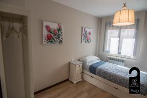 a bedroom with a bed and two pictures on the wall at Cuencaloft Noheda in Cuenca