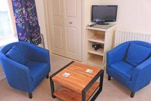 twee blauwe stoelen en een salontafel in de woonkamer bij The Cottage B&B in Porlock