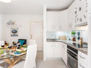 a kitchen with white cabinets and a table with food on it at 205 Los Cristianos by the beach, center, wifi AC in Arona