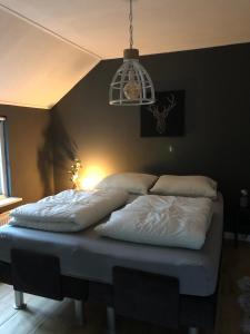 een bed met drie kussens in een kamer bij Veluws rietgedekt bungalow in Ermelo