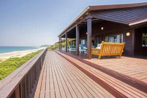 a wooden deck with a bench on the beach at Mar Azul 5 in Ponta Malongane