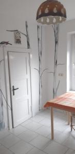 una habitación con una mesa y una puerta con árboles en la pared en Bei Käthe 