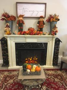 a living room with a fireplace and a table with pumpkins at Starlight Lodge North Conway in North Conway