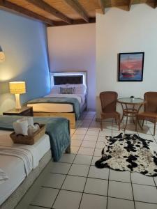 um quarto com 2 camas, uma mesa e cadeiras em Luichy's Seaside Hotel at Playa El Combate em El Combate
