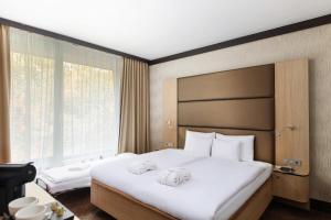 A bed or beds in a room at Portobello Wellness & Yacht Hotel Esztergom