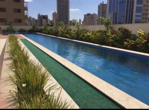 a large swimming pool with a city skyline in the background at Lounge 22 Home Design in Goiânia