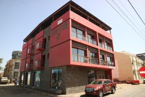 ein rotes Gebäude an der Ecke einer Straße in der Unterkunft Surfzone Beachside Apartments in Santa Maria