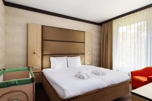 A bed or beds in a room at Portobello Wellness & Yacht Hotel Esztergom