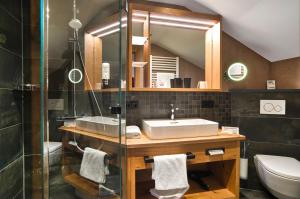 a bathroom with a sink and a mirror and a toilet at Wander- und Aktivhotel Adam Bräu in Bodenmais