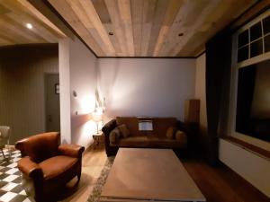 a living room with a couch and two chairs at Vélo 94 in Geel