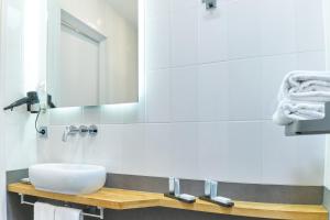 een badkamer met een wastafel en een spiegel bij Alp de Veenen Hotel in Amstelveen