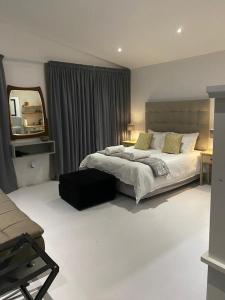a bedroom with a large bed and a mirror at Miles House in George
