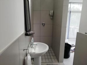 a small bathroom with a sink and a mirror at Miles House in George