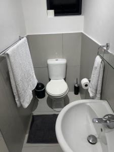 ein Badezimmer mit einem weißen WC und einem Waschbecken in der Unterkunft Miles House in George