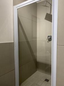 a shower with a glass door in a bathroom at Miles House in George