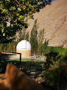 a observatory in a field next to a hill at Refugio Misterios del Elqui in Pisco Elqui