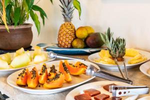 una mesa con platos de fruta y platos de comida en La Proeza Pousada en Búzios